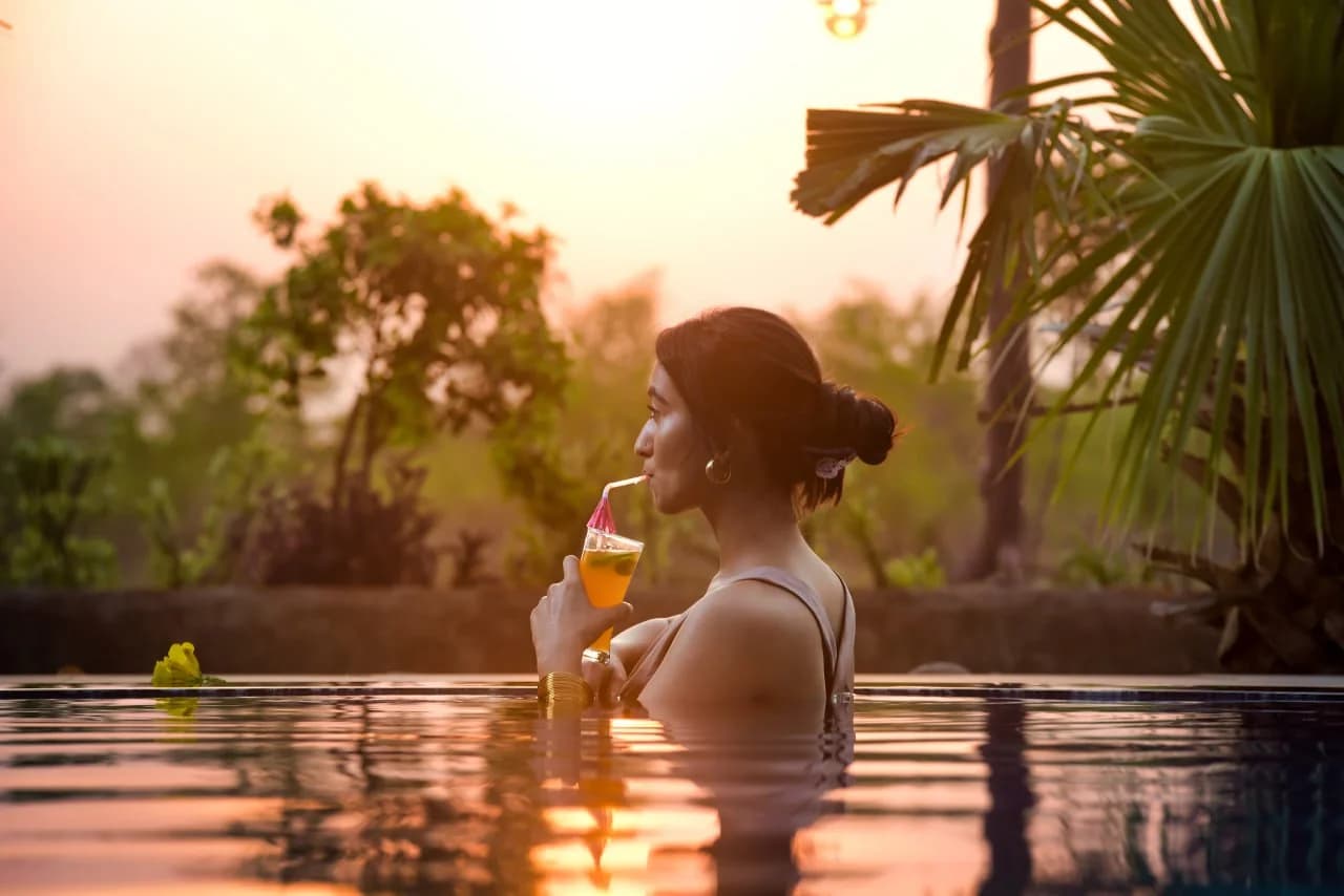 Woman Enjoying Sunset Cocktail in Luxury Swimming Pool